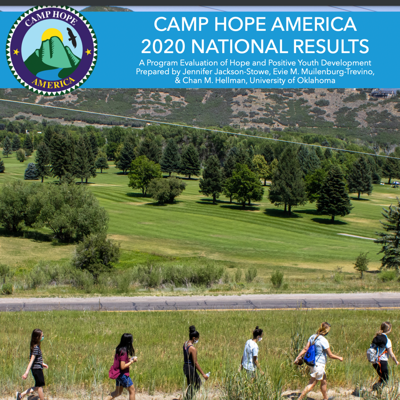 Campers walk through nature with many trees behind them