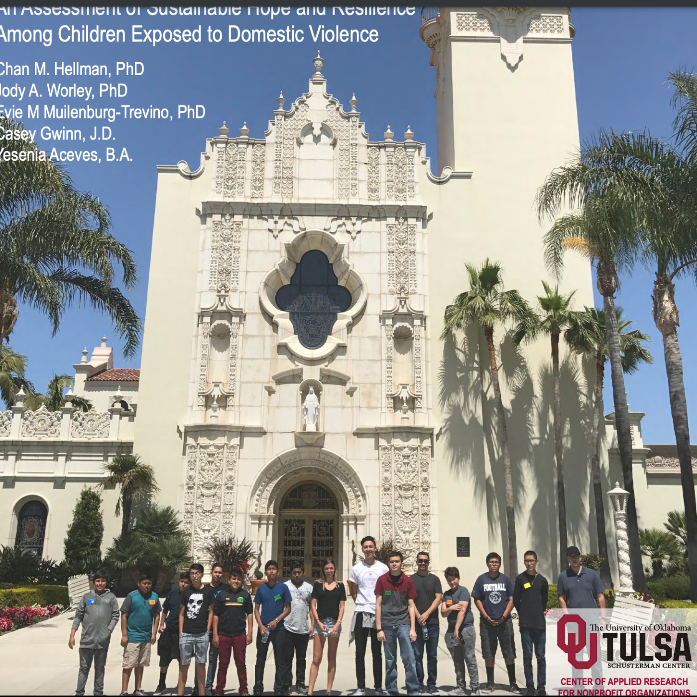 A group of kids stand in front of an extravagant building
