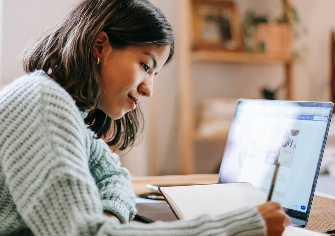 A young woman looking at a laptop screen.
